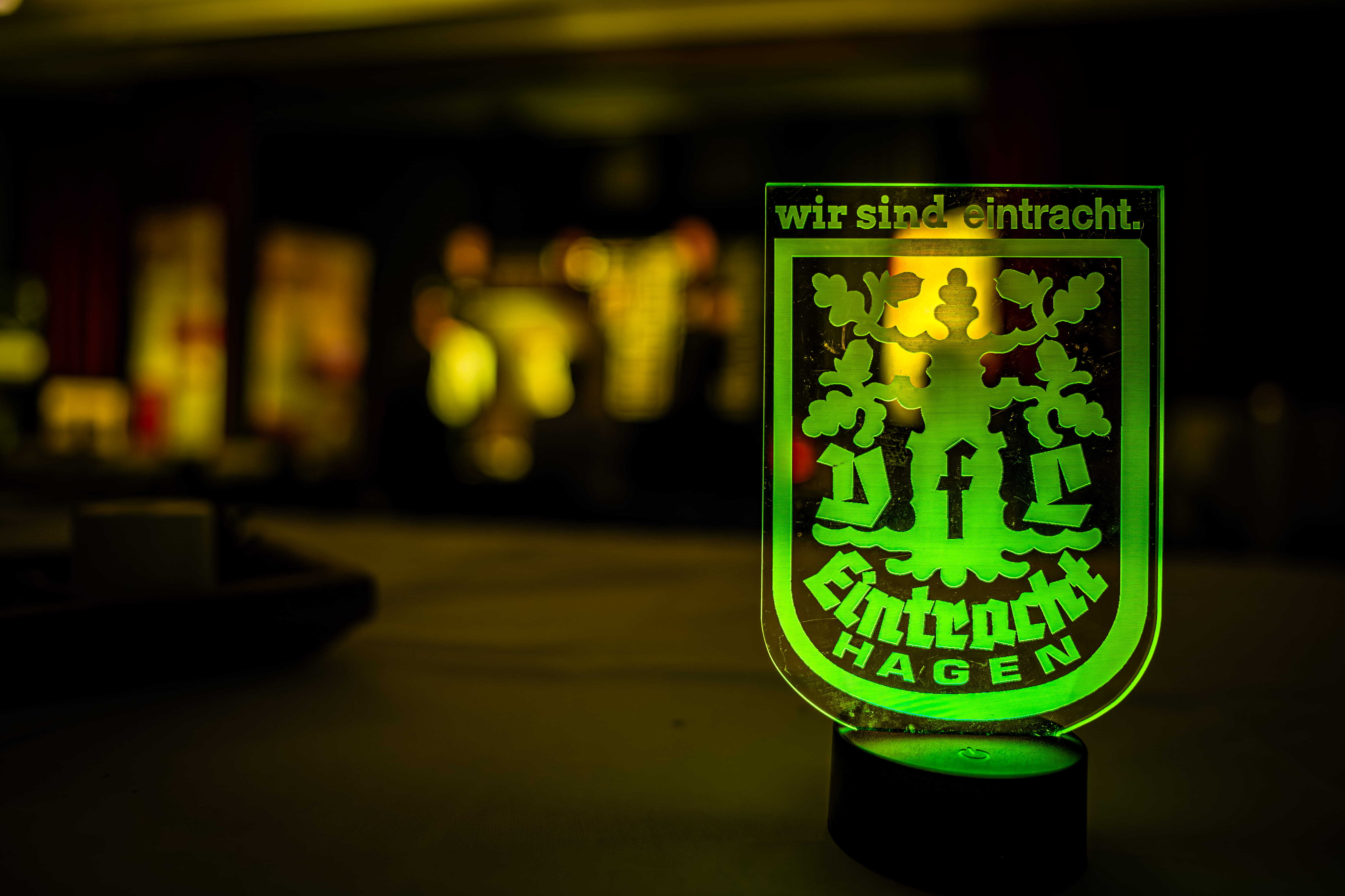 Leuchtendes Eintracht-Hagen-Logo im Business-Club als Symbol für Exklusivität und die Executive Leadership Experience Südwestfalen. Das Bild steht für die gemeinsame Initiative von Andreas Klement und Eintracht Hagen für Unternehmen und Führungskräfte.